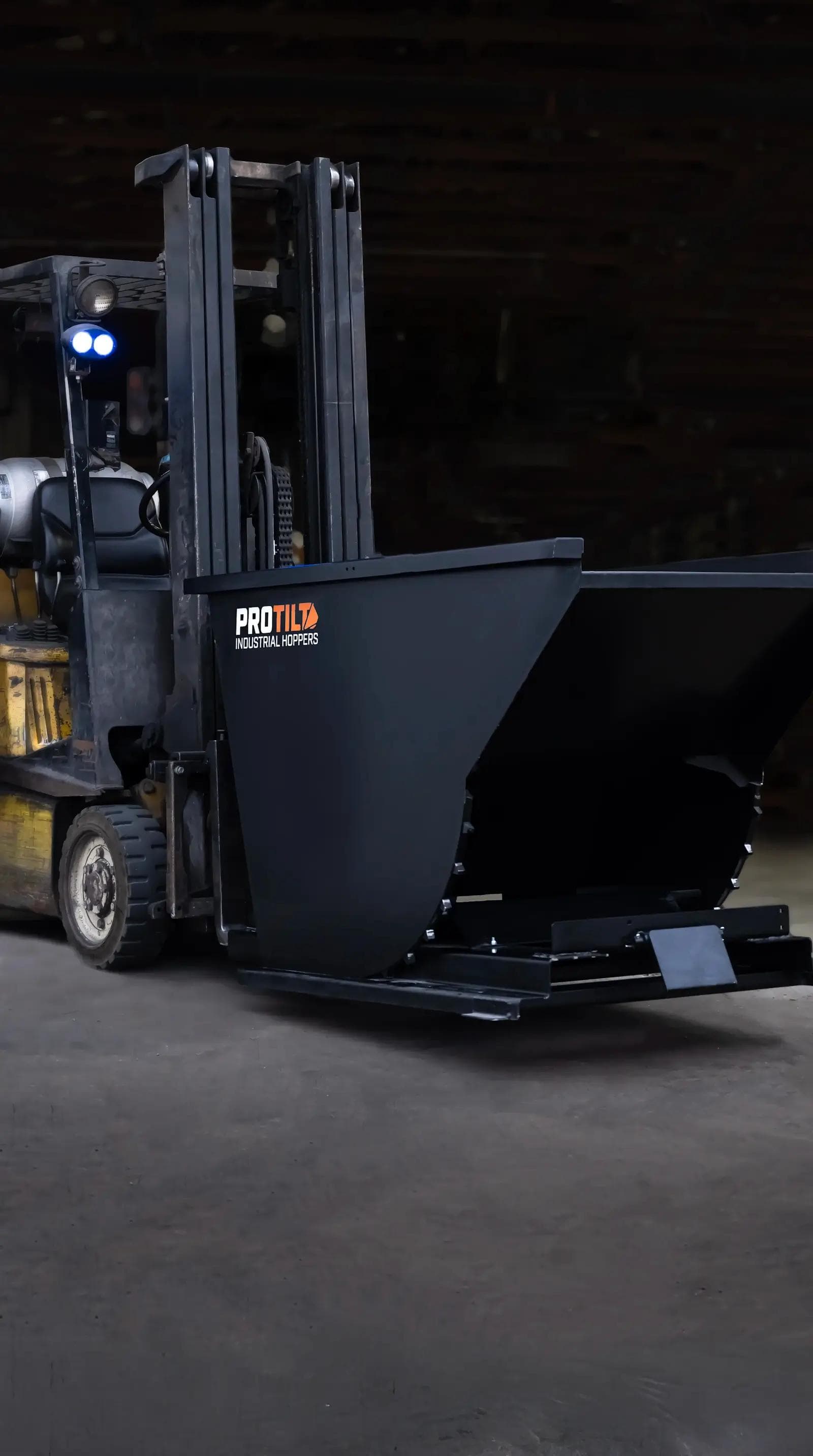 PROTILT self dumping hopper on a forklift ready for industrial material handling.